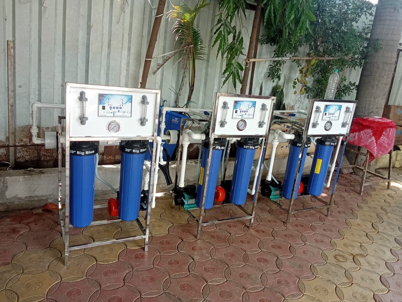 फिल्टर हौसिंग, कंट्रोल पॅनेल व पंपासह शेजारी शेजारी मांडलेली तीन तयार व्यावसायिक RO युनिट्स